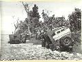 1943. 09. 25. NEW GUINEA. FALL OF LAE. JEEPS BRING SUPPLIES ACROSS A JUNGLE RIVER ON THE ROAD.