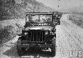 Mortar Company Jeep, with pierced windshield from bullets, is leading a column in orderly retreat. Korea (South)  1951
