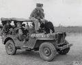 20327581 S MB,A bomber crew of the 390th Bomb Group disembark from a Jeep with their bear mascot 