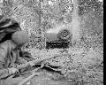 M5474237 GPW A paratrooper takes cover as a jeep burns during a German mortar attack on 1st Airborne Division's HQ at the Hartenstein Hotel in Oosterbeek, 24 September 1944.